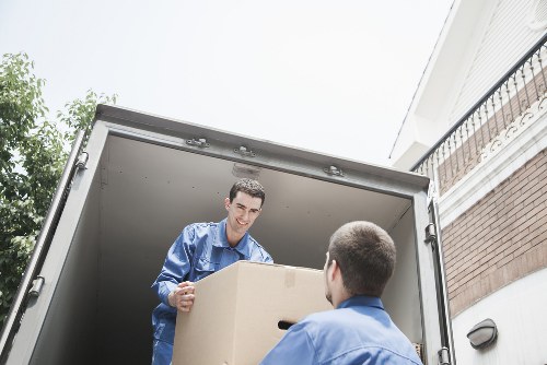 Professional movers handling boxes and furniture in a residential street